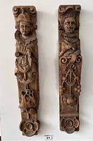 Front view of both carved wood corbels showing male and female figures