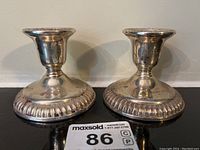 Front view of both sterling silver candlesticks with fluted base detailing