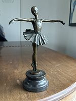 Front view of bronze ballerina sculpture on stone base