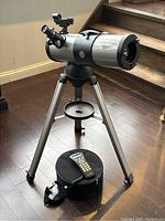 Assembled telescope on tripod with hand controller and soft case on floor
