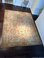 Full view of wool floral carpet on dark hardwood floor