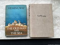 Front view showing For Whom the Bell Tolls cloth-bound volume and The Old Man and the Sea dust jacket.