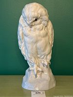Front view of the white porcelain owl sculpture on green background