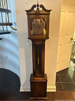 Full view of wooden tall case clock showing entire height and base