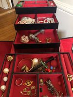 Open multi-tier trays showing assorted rings, bracelets and pendants