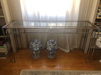 Full front view of 1970s Milo Baughman console table with chrome frame, glass top, and burlwood veneer.