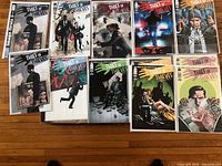 Full view of 10 Thief of Thieves comic book covers numbered 1-9 and 11, arranged in two rows on hardwood floor.