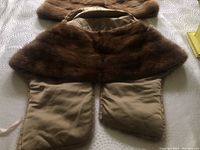 Dark brown mink fur wrap with satin lining and ties, laid flat showing full length and fur texture