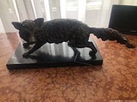 Full side view of bronze fox on marble base