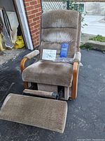 Full view of recliner rocker with footrest extended, manuals and hardware on seat