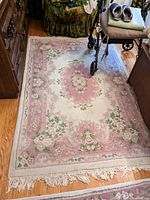 Full view of the Persian area rug placed on hardwood floor with furniture around it, showing the entire rug and fringe edges.