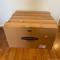 Closed stacked set of large Bankers Box SmoothMove wardrobe boxes with visible labels.