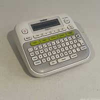 Front view of Brother PT-D210 label printer showing keyboard and monochrome display screen containing text "PT-D210".