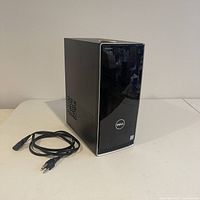 Front and side view of Dell Inspiron 3668 desktop computer tower with included power cable shown on table.