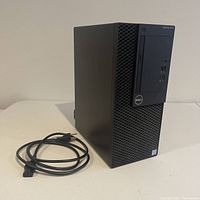 Front side of Dell OptiPlex 3050 tower with power cable on table