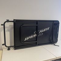 Folded Ellen Croft Supreme Pilates Machine showing the padded surface with brand logo.