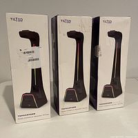 Front of three Tilted Nation TNPhantomB gaming headset and controller stands in boxes, showing product image and brand.