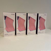 Four boxed Tilted Nation Pink TNFIREP RGB gaming mouse pads showing front packaging with image and product name.