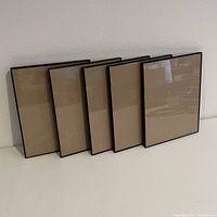 Five leaning black frames at an angle showing front clear display and slim frame edge