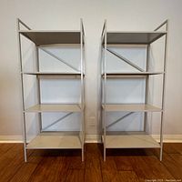 Front view of the two metal bookshelves side by side showing four shelves each.