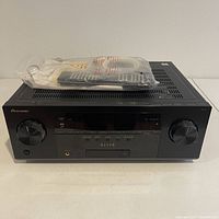 Front view of the Pioneer Elite VSX-51 7.1-Channel A/V Receiver with remote control and cables on top in plastic bag