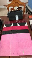 Black classic size Miche handbag with five interchangeable covers laid flat revealing snap buttons and textures in black, red, and pink faux crocodile finishes.