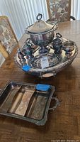 Full view of the silver tone serving set with multiple pieces including a large covered bowl, smaller containers, and an oval large serving tray with handles.