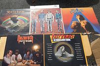 Photo of five 70s and early 80s rock vinyl records showing the front covers including Rainbow's Rising, Nazareth, The Police, and others.