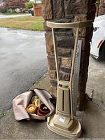 Full view of Electrolux B-50 floor polisher with upright beige body and attached label. Bag of polishing pads seen on the ground next to it.
