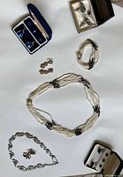 Lot overview including pearl necklace and bracelet, multiple sets of cufflinks, earrings, and silver-tone bracelet.