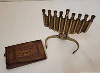 Brass nine-branch menorah with a decorative emblem on the base showing patina and aged finish.