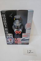 Front view of sealed Robot B-9 box showing figure inside with 'Lost in Space' logo and Try Me sound/button instruction.