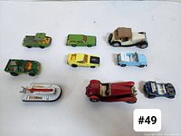 Top view of 9 Matchbox toy vehicles arranged in rows on white background