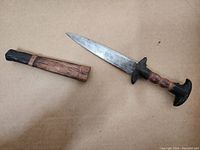 Full view of dagger and scabbard on cardboard background