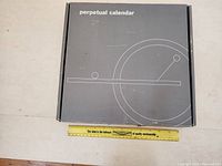 Front view of the perpetual calendar box showing minimalist line art design and product name.