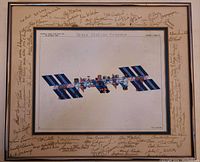Front view of framed printed illustration of Space Station Freedom showing full concept design and surrounding signatures