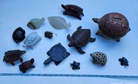 Overview of turtle collection showing variety of carved and painted figurines in different sizes and materials.