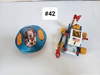 Front view of Little Nellie gyrocopter and James Bond Moon Buggy showing primary colors and details