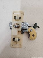 Front side view of the vintage cap gun in plastic belt clip holster showing detailed engravings and plastic grips with 'N' insignia