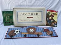 Framed 'My Room Girls Not Allowed' wall plaque, sports-themed wall plaque with four hooks featuring sports equipment, two books: 'Watch Out Otto' and 'The Pocket Dangerous Book for Boys'.