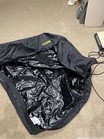 Interior view of the car top carrier showing shiny waterproof lining and black fabric.