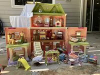 Front view of doll house open with various dolls and accessories arranged