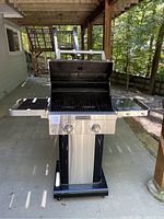Full frontal view of the KitchenAid gas grill with both side surfaces attached and open lid, showing console with two knobs and brand label.