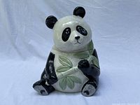 Full view of the ceramic panda cookie jar with lid closed showing the sitting panda holding bamboo leaves.