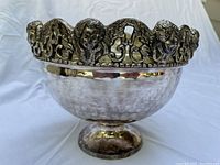 Side view of silver plated cherub bowl showing hammered texture and cherub-decorated rim.
