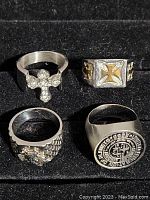 Front view showing four rings with various designs including Starfleet Academy logo, gold crosses, eagle head and fleur-de-lis cross
