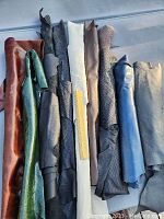 Nine assorted leather remnants from Italy arranged in a row showing their color variety and textures
