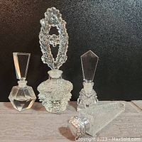 Overview of all four vintage glass perfume bottles showing variety in stopper design and bottle shapes.