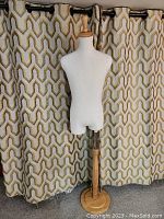 Front view showing the full mannequin torso, fabric covering, wooden finial top, and base stand.