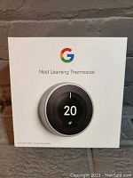 Front view of the unopened Google Nest Learning Thermostat box showing the device image and Google logo.
